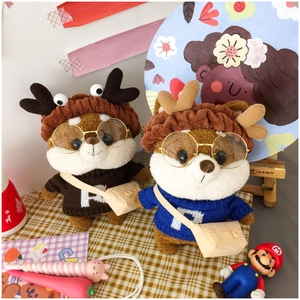 Detail of plush Shiba Inu dolls wearing deer horn hats, knitted sweaters and small glasses