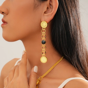 Detail showing vintage golden drop oil earrings and chunky chain necklace on model
