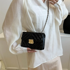 Black patent leather quilted crossbody bag with gold chain strap and square lock