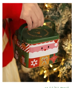 Primo piano di una scatola regalo natalizia in latta con manico e Babbo Natale