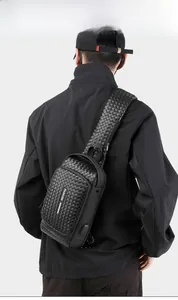 Detail of men's black woven chest bag featuring a built-in USB external charging port