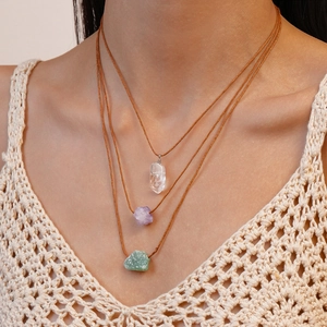 Three-piece bohemian set of natural crystal pendant necklaces with brown cords on model