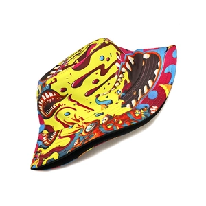 Détail d'un chapeau bob jaune avec imprimé graffiti de monstres colorés et toile de coton robuste
