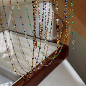 Macro shot of 18k gold-plated stainless steel chain with colorful enamel beads