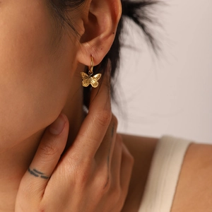 Elegant 18K gold plated stainless steel butterfly drop earrings worn by a model