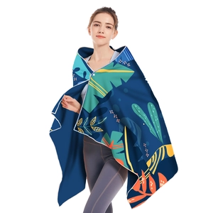 Detail of hooded microfiber beach towel featuring vibrant tropical leaf pattern and white piping