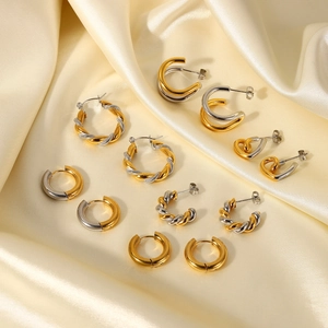 Fashionable 18k gold plated mixed tone geometric hoop earrings on beige silk fabric
