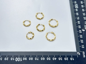 Detailed view of three pairs of gold twisted hoop earrings with size measurement ruler