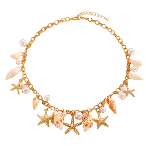 Detailed shot of golden beach necklace featuring sea shells, pearls and starfish charms