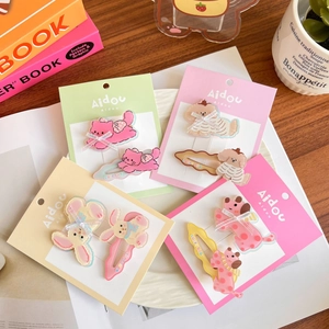 Cute acrylic animal hair clips with bow details displayed on a decorative white ceramic plate