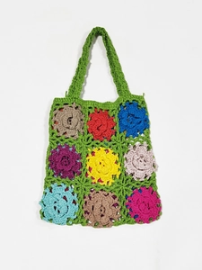 Detail of colorful handmade crochet tote bag featuring multi-color granny square floral pattern