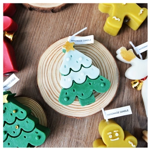 Detail of handmade Christmas candles in shapes of green tree, gingerbread man and reindeer