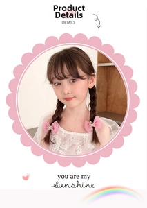 Pink tulle bow hair clip with pearl crown detail worn on a young girl's braided hair