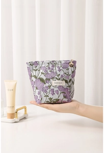 Close-up of purple floral canvas makeup bag with a decorative flower zipper pull
