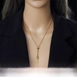 Detail of adjustable gold stainless steel teardrop pendant necklace on a model