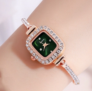 Detail view of a rose gold square ladies watch with green dial and rhinestone bracelet