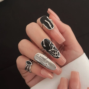 Detail of four-piece gothic punk nail rings set with silver fluid metal and black enamel