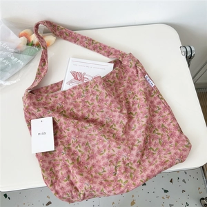 Detailed texture of pink floral corduroy tote bag with MISS label on a white table