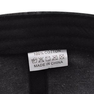 Détail de l'étiquette de lavage 100% coton et qualité de couture sur casquette noire
