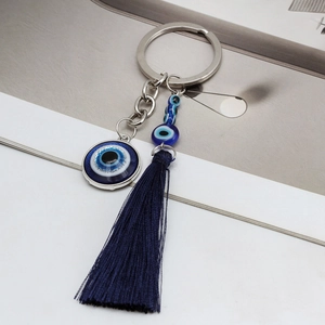 Detail view of ethnic evil eye keychain featuring blue beads and a dark blue silk tassel