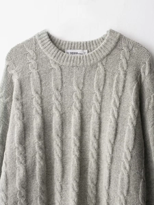 Close-up of a grey cable-knit sweater neckline showing high-quality knitted fabric detail