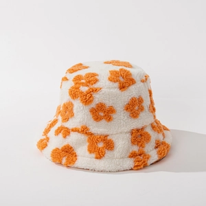 Detail of soft white plush bucket hat featuring orange floral embroidery and warm texture