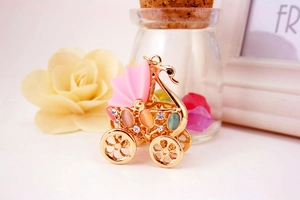 Detailed view of swan stroller keychain with colorful cat eye stones and rhinestones