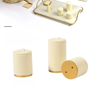 Macro detail of beige velvet jewelry display set with luxury gold metal finish