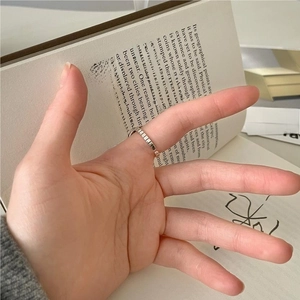 Detailed view of a gold geometric textured ring worn while reading an aesthetic book