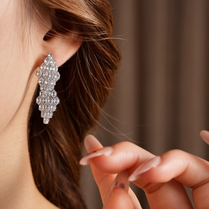 Macro view of geometric silver rhodium earrings with sparkling cubic zirconia crystals