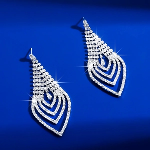 Macro view of silver geometric teardrop earrings with multi-layer white rhinestones
