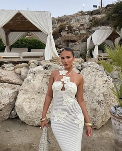 Detail of white crochet vacation dress with 3D floral accents and halter neckline