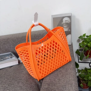 Detail of bright orange hollow mesh jelly basket showing soft silicone texture and dual handles