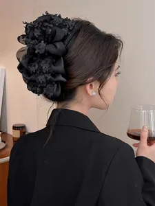 Vue détaillée d'un chouchou floral élégant en organza noir sur une chevelure