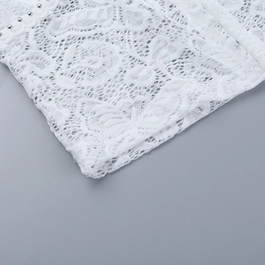 Vue macro détaillée de dentelle blanche avec ornements de fines perles argentées