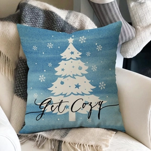 Detail of blue Christmas pillow cover with Get Cozy text and snowflake patterns on a chair