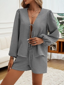 Dettaglio del set loungewear a scacchi bianco e nero con top con scollo a V e pantaloncini