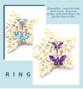 Detail view of double butterfly belly button rings with blue and purple faceted crystals