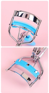 Detail of portable stainless steel eyelash curler with blue comb pad on pink background