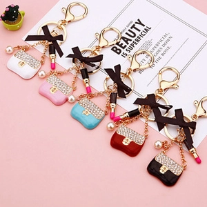 Close-up of pearl handbag keychains with lipstick charms in five vibrant colors