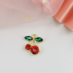 Macro view of red and green cherry zircon pendant with gold-plated alloy base