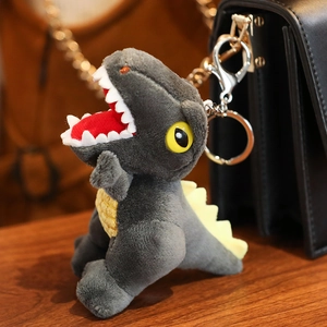 Plush grey dinosaur keychain with yellow scales and silver metal clip for backpacks