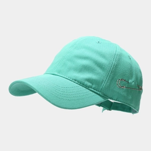 Detail shot of mint green cotton baseball cap with silver metal safety pin accessory