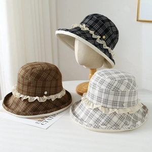 Detailed view of plaid bucket hats with lace trim and floral accents in various colors