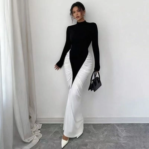 Détails des fronces latérales et du contraste noir et blanc sur la robe longue moulante