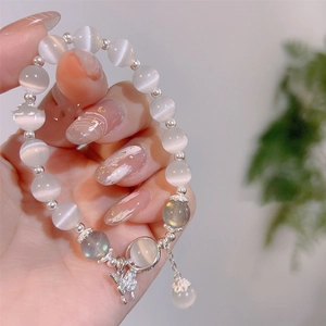 Vue détaillée du bracelet en œil de chat blanc avec pendentif lapin et perles de lune