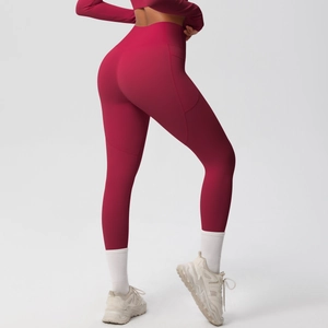 Detail of high waisted burgundy yoga leggings with functional side pockets and smooth fabric