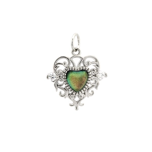 Macro shot of silver-plated heart pendant with green crystal and filigree details