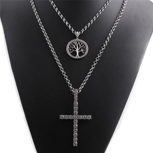 Close-up of double-layer silver tree of life and cross pendants with rhinestones