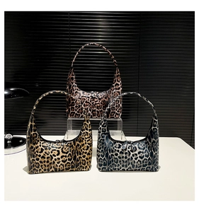 Detailed view of three leopard print bucket bags in brown, yellow, and greyish black colors